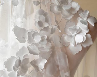 May include: White bridal veil with delicate floral appliques. The veil is made of soft tulle and features 3D flowers that add a touch of elegance and romance.
