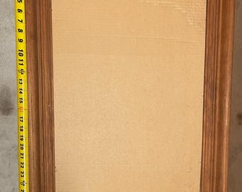 May include: A rectangular wooden picture frame with a light brown finish. The frame measures approximately 76 cm in height. The frame has a simple, classic design, with a cardboard backing.