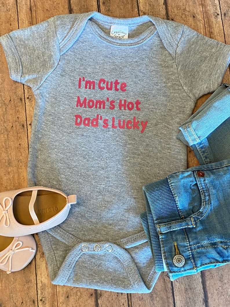 Trendy baby bodysuit available in multi colors! Dad/'s LUCKY I/'m CUTE Funny Baby Bodysuit for your new little one Mom/'s HOT