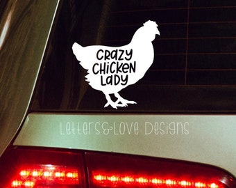 May include: White vinyl decal of a chicken silhouette with the text "Crazy Chicken Lady" on a car window. The decal is on a dark gray car with red taillights. The text "Letters & Love Designs" is below the decal.