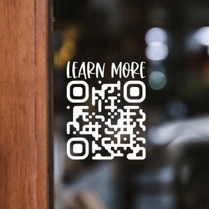 May include: A white sticker on a glass door with the text "LEARN MORE" and a black and white QR code.