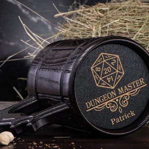 May include: Black wooden beer stein with a handle and a black and gold engraved design of a 20-sided die and the text "Dungeon Master Patrick".