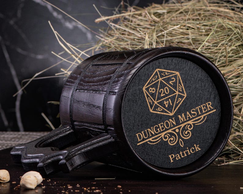 May include: Black wooden beer stein with a handle and a black and gold engraved design of a 20-sided die and the text "Dungeon Master Patrick".
