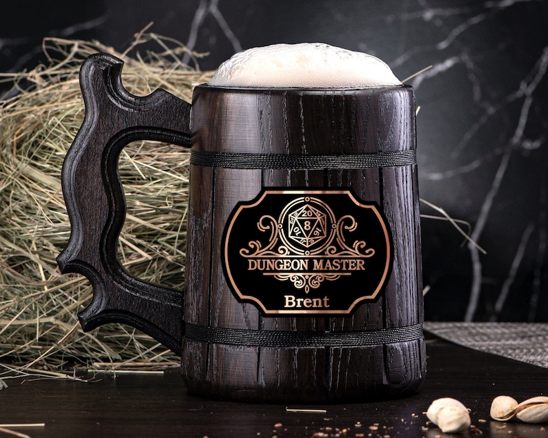May include: A dark brown wooden beer stein with a black band around the top and a metal plaque with the words "Dungeon Master" and "Brent". The plaque also features a gold-colored 20-sided die.