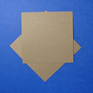 May include: Two pieces of brown craft paper are stacked on top of each other, forming a diamond shape against a blue background.