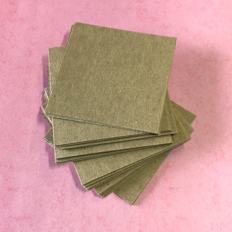 May include: A stack of brown paper squares, likely for crafting or scrapbooking.