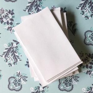 May include: A stack of white paper sheets on a blue and white patterned surface.