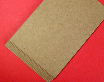 May include: A stack of brown cardstock paper. The paper has a rough, textured surface.