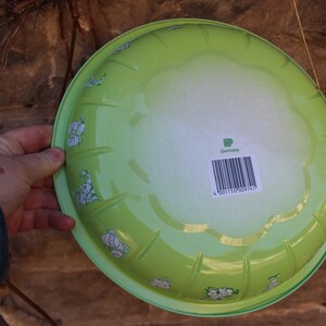 May include: A green enamelware bowl with a white floral design and a barcode label that reads "Germany".