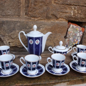 May include: A vintage tea set with a blue and white floral pattern. The set includes a teapot, sugar bowl, and six cups and saucers.