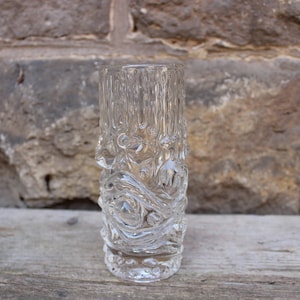 May include: A clear glass vase with a textured, wavy design. The vase is approximately 13 cm tall.
