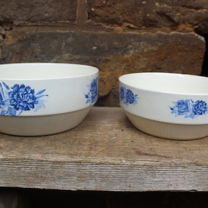 Könnte beinhalten: Zwei weiße Keramikschalen mit blauen Blumendesigns. Die größere Schale befindet sich im Vordergrund und die kleinere Schale im Hintergrund.