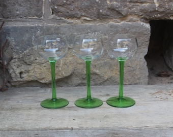 Tres copas de vino Art Nouveau, sopladas a boca, con tallo verde y cristal.