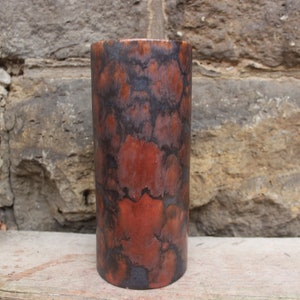 Può includere: Un vaso cilindrico in ceramica con una smaltatura marmoreggiata marrone e nera. Il vaso ha una finitura liscia e lucida.