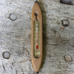 Puede incluir: Un termómetro de madera con forma de lápiz con una línea de mercurio roja que indica una temperatura de 15 grados Celsius. El termómetro está etiquetado con "OTTAWA HYDROMETER AND SCALE CO.  MADE IN CANADA"