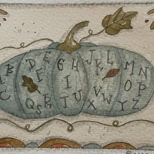 May include: Watercolour painting of a blue-green pumpkin with the alphabet painted on it. The pumpkin has a green stem and a leaf. The background is a light beige with decorative elements.
