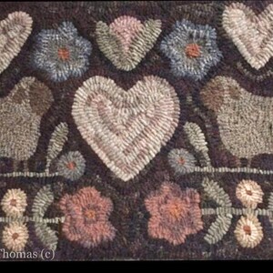 May include: A brown rug with a white heart, two white sheep, and a floral design. The rug is made of wool and has a hand-stitched look. The text "Rhonda Thomas (c)" is in the bottom left corner.