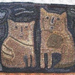 May include: A rug with a dark blue background and two brown cats. The cats are sitting side by side and are facing forward. The rug is made of wool and has a hand-stitched look.
