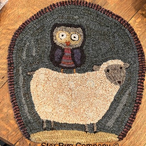 May include: A hand-hooked wool rug featuring a white sheep with a brown face and an owl perched on its back. The owl has a brown body with a purple and red striped shirt. The rug has a dark blue background and a brown border. The rug is signed "Star Rug Company".