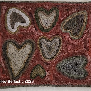 May include: A handmade rug with a repeating heart pattern. The rug features hearts in shades of gray, green, and brown against a red background. The text "Kelley Belfast c 2026" is visible in the bottom left corner.