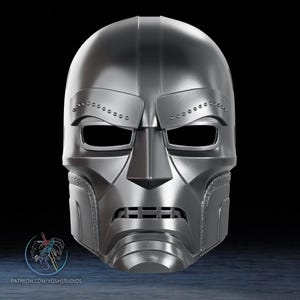May include: A metallic silver mask with a distinctive design, featuring a prominent brow, rectangular eye openings, and a detailed lower face. The mask has rivets along the brow and a textured finish. The overall aesthetic suggests a futuristic or superhero theme.