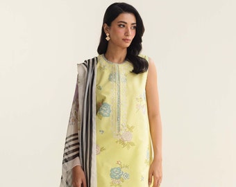 May include: A yellow sleeveless kurta with floral embroidery and a matching pair of pants. The kurta has a round neckline and a scalloped hem. The pants have a scalloped hem and are paired with a white sheer dupatta with black stripes.