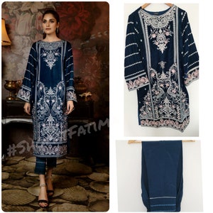 May include: A dark blue velvet kurta with silver and pink embroidery. The kurta has a round neckline and long sleeves. The pants are also dark blue and have a silver trim. The image includes the hashtag #ShopFatima.