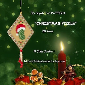 Könnte beinhalten: Ein 3D-Peyote-Pod-Muster für einen Weihnachtsgurken-Anhänger. Das Muster hat 28 Reihen und zeigt eine grüne Gurke mit einem roten Weihnachtsmann-Hut. Das Muster stammt von Jane Junker und ist auf shinybeadart.etsy.com erhältlich.