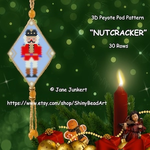 May include: A 3D Peyote Pod pattern for a Nutcracker ornament, with 30 rows. The pattern is shown on a blue and white diamond-shaped beadwork ornament with a gold trim. The ornament is hanging from a string of beads. The background is a green Christmas tree with a red candle and other Christmas decorations.