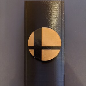 May include: A black box with a brown and black Nintendo Smash Bros. logo on the front.