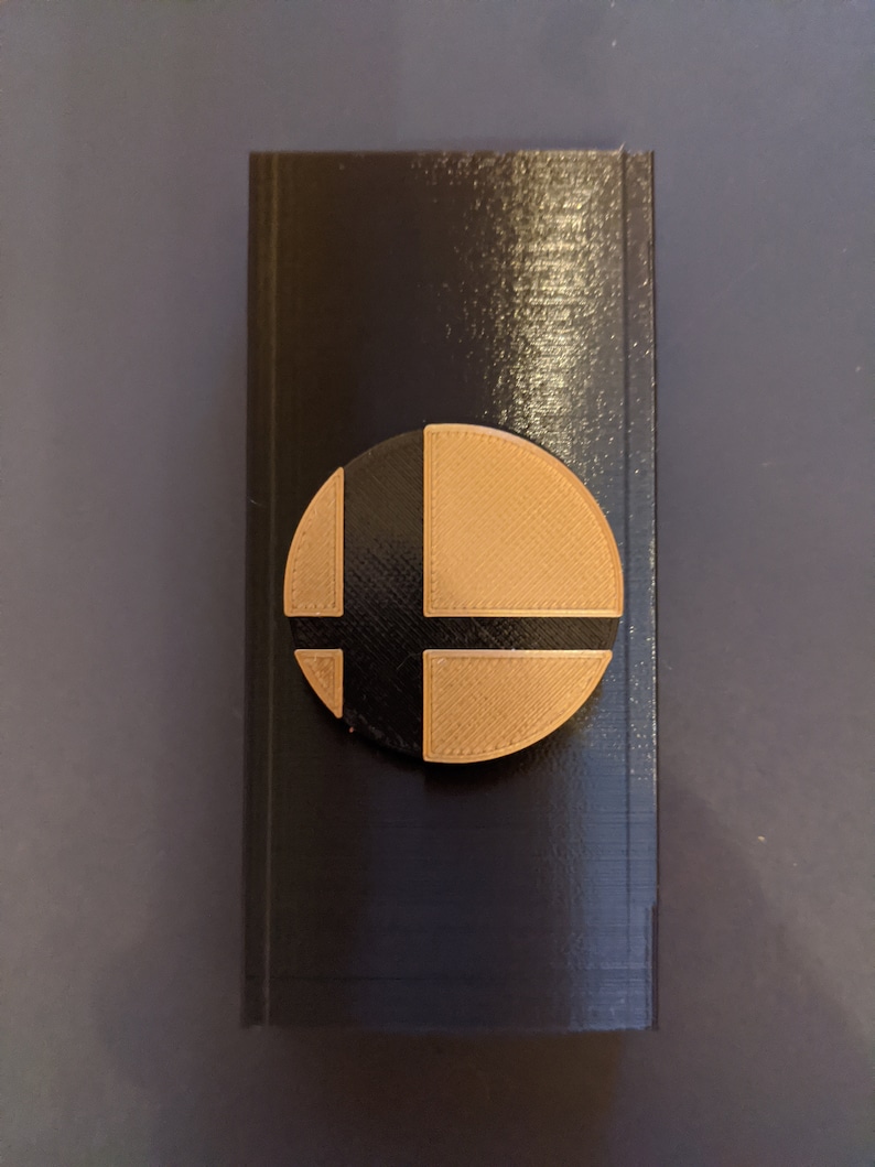 May include: A black box with a brown and black Nintendo Smash Bros. logo on the front.