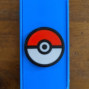 May include: A blue plastic case with a black, white and red Pokeball design.