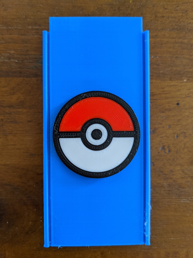May include: A blue plastic case with a black, white and red Pokeball design.