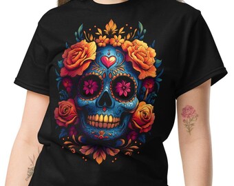 May include: Black t-shirt featuring a vibrant, detailed sugar skull design. The skull is blue with floral accents, including orange roses and flower-filled eye sockets. A heart is centered on the forehead. The design is a colorful representation of the Day of the Dead.