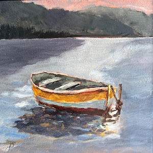 May include: A yellow and white wooden boat sits in still water with a dark green mountain range in the background. The boat is tied to a dock with a rope.