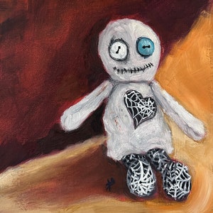 May include: A white rag doll with a stitched smile and one blue button eye. The doll has a black heart with a spiderweb design on its chest and is wearing black and white spiderweb patterned pants.