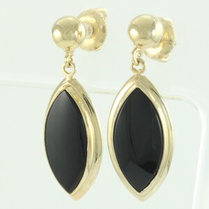 May include: A pair of gold-colored drop earrings with a black, marquise-shaped onyx stone. The earrings have a post-and-stud closure and a gold-colored frame around the black stone.