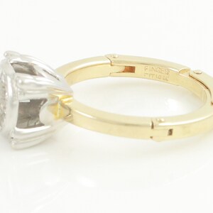 May include: A gold and white ring with a diamond center stone. The ring is a size 7 and is made of 14k gold. The ring is engraved with the word "Finger" and the number "14k".