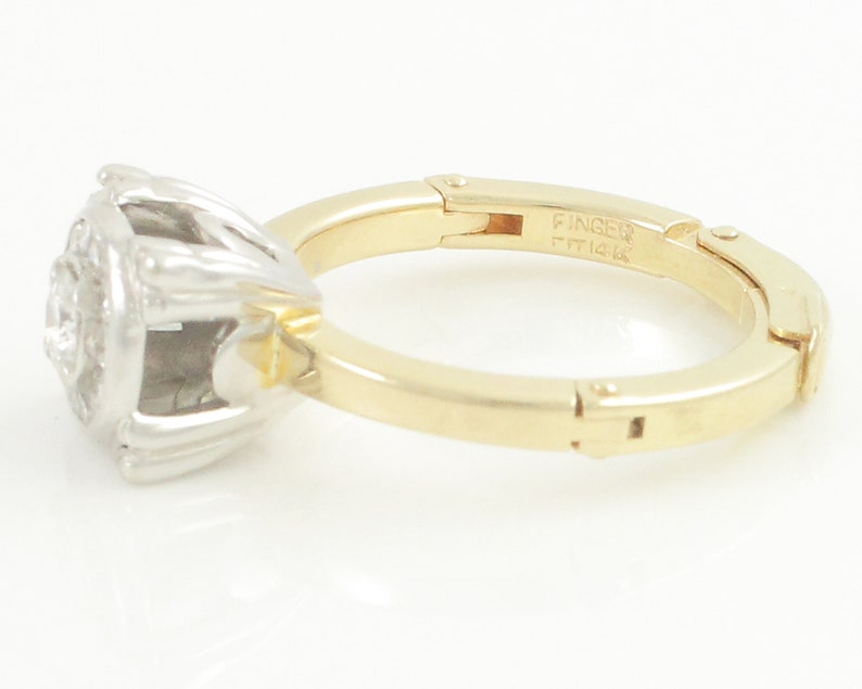 May include: A gold and white ring with a diamond center stone. The ring is a size 7 and is made of 14k gold. The ring is engraved with the word "Finger" and the number "14k".