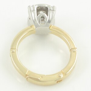 May include: A gold and white ring with a hinged band and a diamond setting.