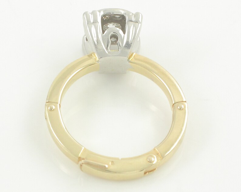May include: A gold and white ring with a hinged band and a diamond setting.
