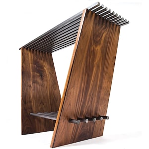 May include: A modern, geometric side table with a walnut wood frame and a metal slat top. The table has a unique angled design and features metal accents.