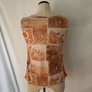 May include: A sleeveless top with a brown and white patterned design featuring birds and flowers. The top is made of a sheer fabric.