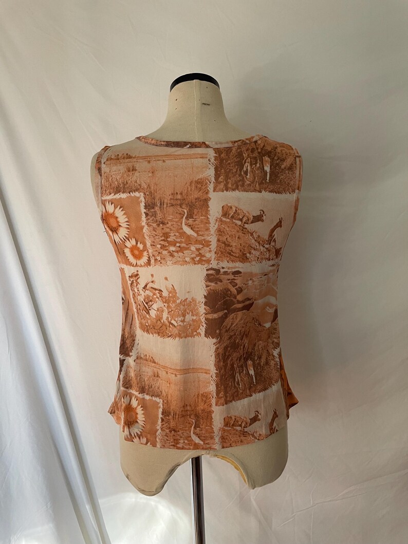 May include: A sleeveless top with a brown and white patterned design featuring birds and flowers. The top is made of a sheer fabric.
