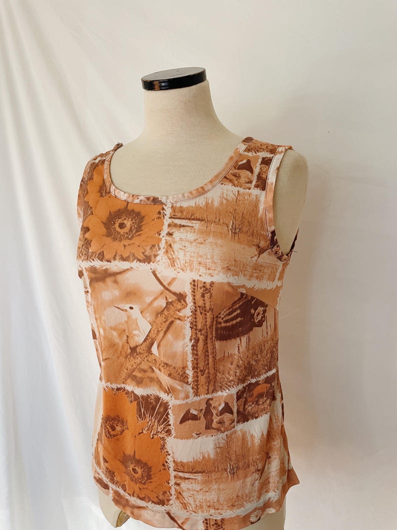 May include: A sleeveless top with a brown and white patchwork design featuring birds, flowers, and cacti.