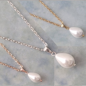 Einfache Tropfen-Perlen-Tropfen-hängende Halskette. Einzelner weißer oder elfenbeinfarbener Perlenanhänger an einer weißen Kette, Gold, Silber oder Rosévergoldet