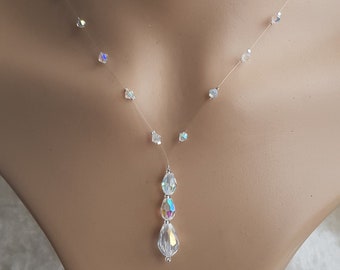 May include: A delicate clear necklace with a teardrop-shaped crystal pendant. The necklace features small crystal accents along the chain.