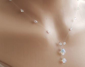 May include: A delicate, clear crystal necklace with a teardrop pendant. The necklace features small, iridescent crystals spaced along the chain.