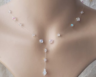 May include: A delicate, clear crystal necklace with a single drop pendant. The necklace features small, iridescent crystals strung on a thin, invisible wire.