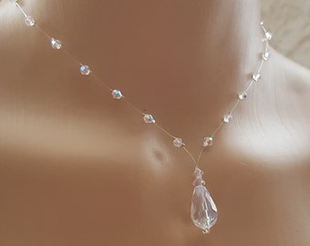 May include: A delicate crystal necklace with a teardrop pendant. The necklace is made of clear crystal beads strung on a thin, clear thread. The pendant is a large, faceted crystal that hangs from the center of the necklace.